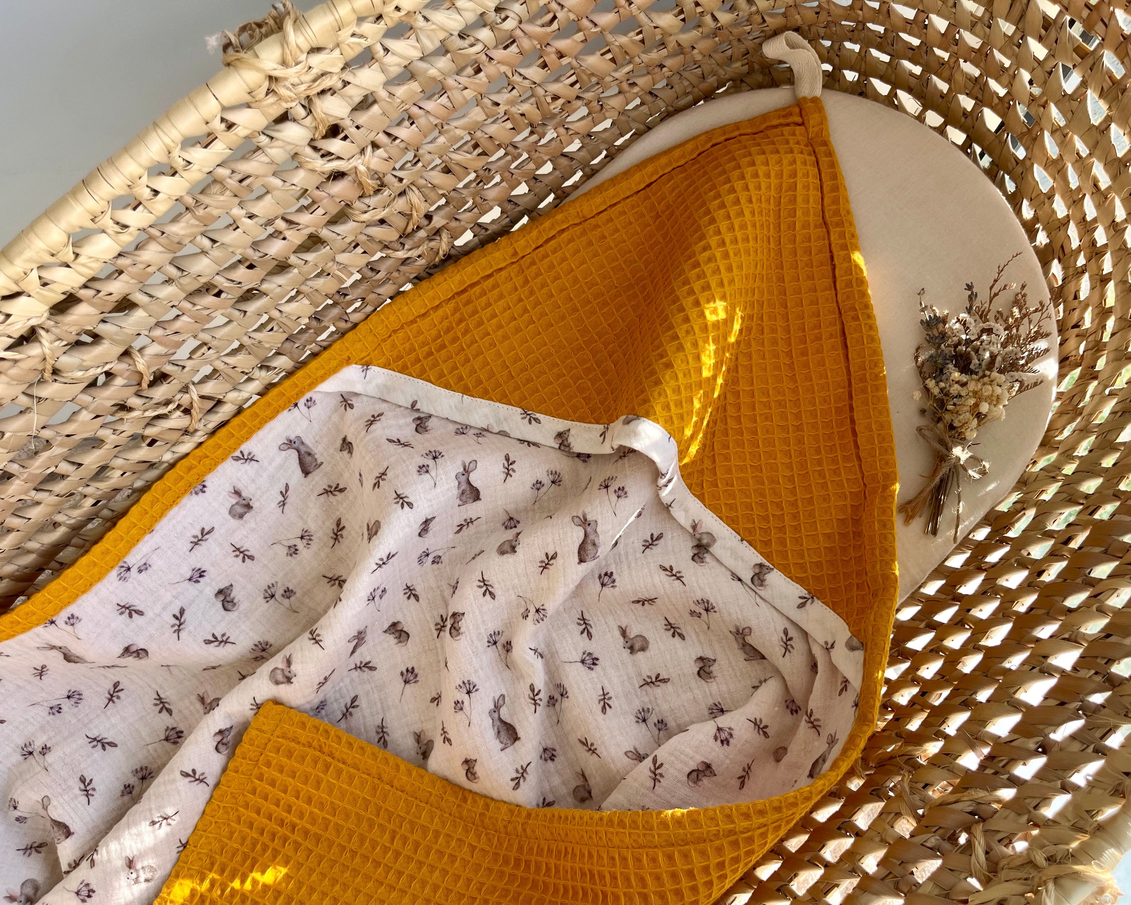Mustard yellow textured fabric with a white patterned fabric inside a woven basket.